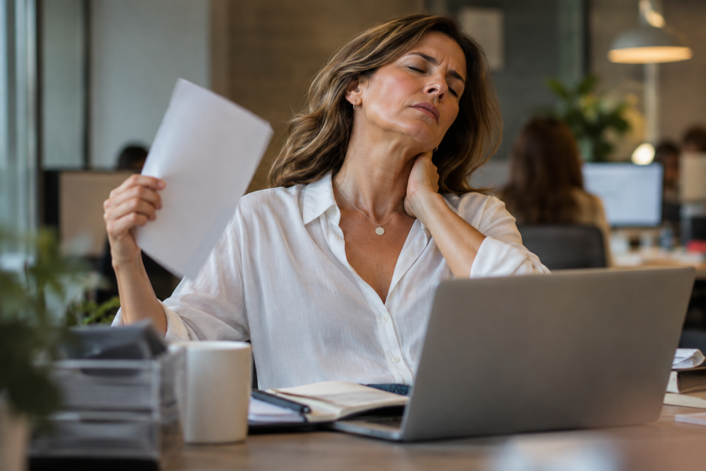 Mujer trabajadora afrontando síntomas de la menopausia en su entorno laboral